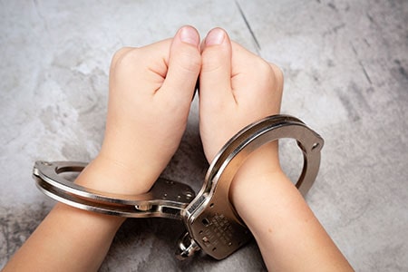 Young Child's Hands in Handcuffs